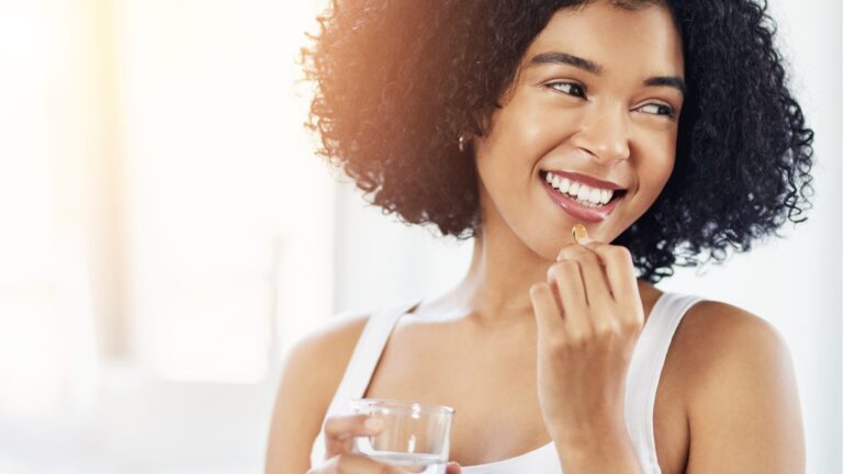 mulher tomando suplemento capilar